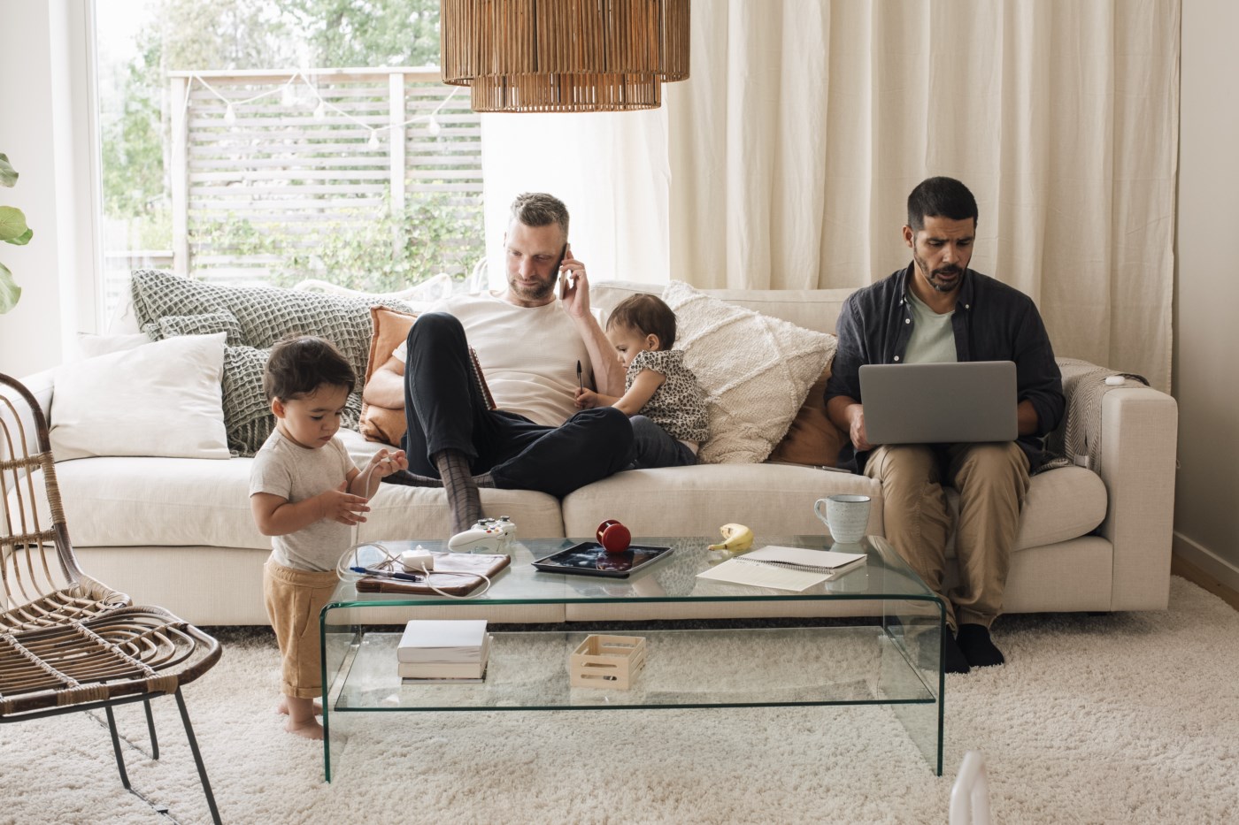 Ung jente og gutt sitter i sofaen blant flytteesker med mobil