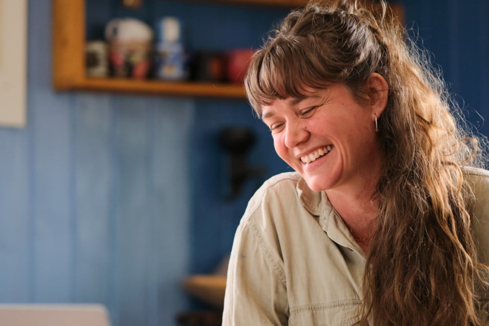 En dame smiler på kjøkkenet